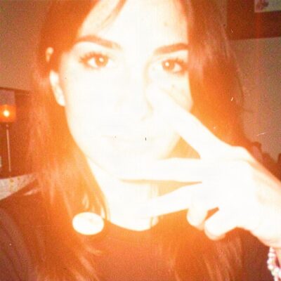 A heavily filtered webcam photo with a peace sign.